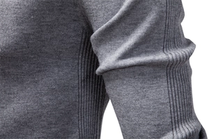 Detail view of grey knit sweater showing side ribbing and high-quality fabric texture