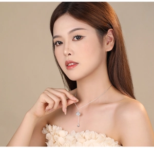 Silver ginkgo leaf necklace with tassel and zircon inlay shown on female neck