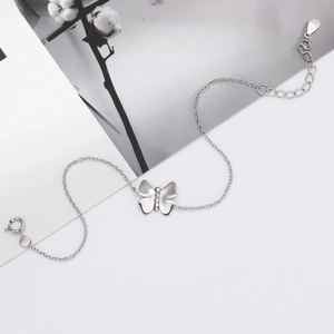 Close-up of S925 silver butterfly pendant bracelet with delicate chain and lobster clasp
