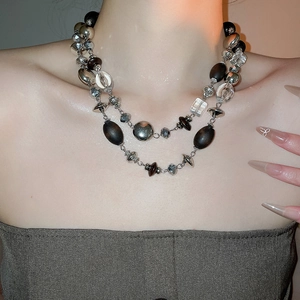 Detail shot of a double-layered vintage necklace with wooden, metallic and crystal beads