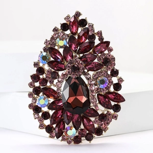 Macro shot of vintage gold teardrop brooch with purple and pink crystal rhinestones