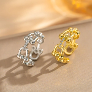 Detail of gold and silver U-shaped chain link rings with sparkling pavé zircon stones