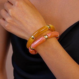 Vue détaillée de bracelets en résine ambre et acrylique marbré avec bagues dorées