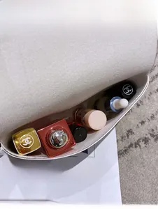 Interior view of small crossbody bag showing storage capacity for cosmetics and lipstick