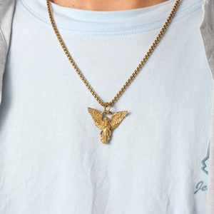 Close-up of a vintage gold guardian angel pendant with box chain on a model