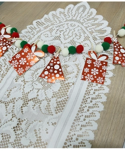 Close-up of Christmas bunting with red gift box cards and white lace table runner detail