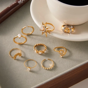 Detailset aus neun goldenen Titanringen mit Sonnenmustern und Zirkon-Inlays auf Tablett