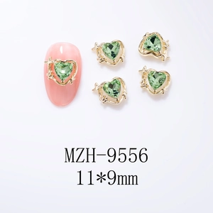 Détail de breloque ongle cœur 11x9mm avec gemme verte et cadre étoilé doré