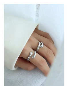 Detailed view of silver hugging hands open rings with high polished mirror finish