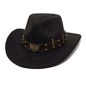 Dettaglio di cappello cowboy nero con cinturino in pelle, borchie e stemma aquila