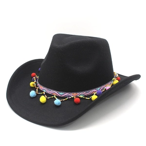 Détail d'un chapeau de cowboy noir avec bande tissée bohème et pompons multicolores