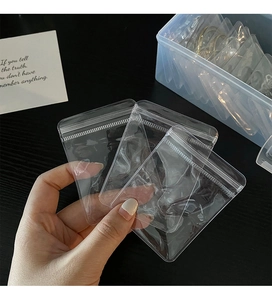 Hand holding transparent plastic anti-oxidation jewelry storage bags for earrings and rings