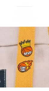 Detail of MVP crown and Game Time flame basketball enamel pins on yellow bag strap