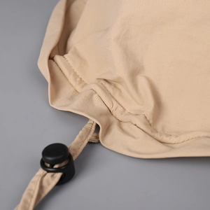 Close-up of beige sun hat drawstring with black adjustable toggle for outdoor sun protection