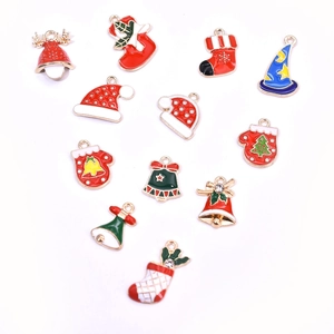 Flat lay of colorful enamel Christmas charms including red socks, hats and golden bells