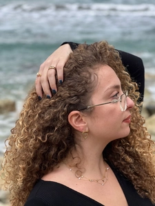 Gros plan de boucles d'oreilles cœur dorées avec nœud et collier sur mannequin