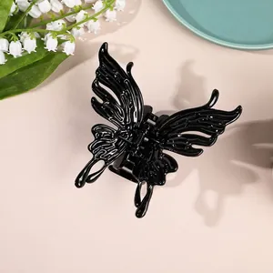 Close-up of a black butterfly hair claw with hollow wing design on an elegant background