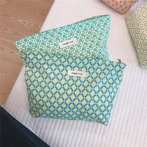 Close-up of floral cotton cosmetic bag with zipper and simple wish woven label
