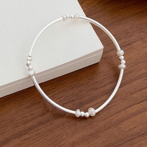 Close-up of S925 sterling silver beaded bracelet with freshwater pearls on white paper