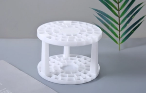 Detail view of a white circular makeup brush holder with a multi-slot plastic design