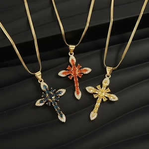 Detailed view of colorful zircon cross necklaces in blue orange and yellow on gold chains