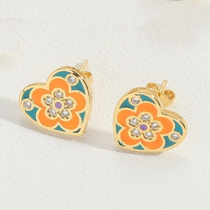 Macro shot of heart-shaped floral earrings with enamel finish and cubic zirconia