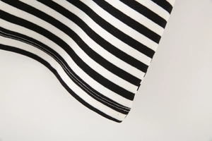 Detail view of black and white striped fabric texture and double-needle hem stitching