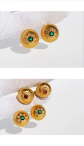 Macro detail of French vintage gold disc stud earrings with red and green zircon stones