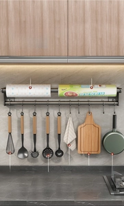 Detail of wall-mounted kitchen rack with sliding hooks for utensils and paper roll holder