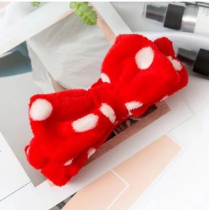 Close-up of red plush headband with white polka dots and a soft oversized bow design