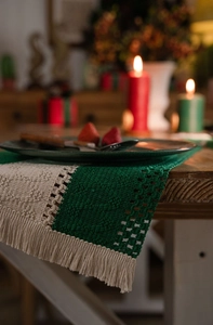 Detail of hand-woven cotton table runner with green beige stripes and tassels for Christmas