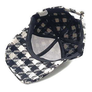 Detail view of houndstooth baseball cap featuring 100% polyester fabric and inner lining