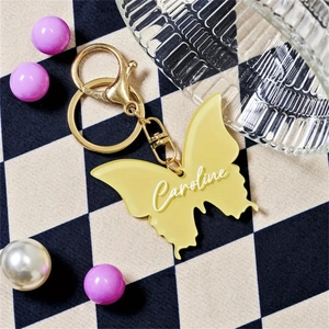 Detail of yellow translucent butterfly keychain with custom Caroline name engraving