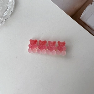 Close-up of pink translucent gummy bear hair clip with four matte resin bears in a row