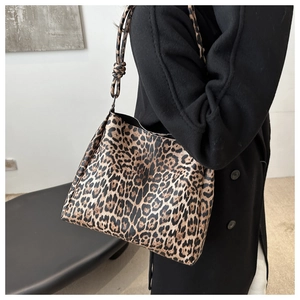 Fashionable leopard print tote bag worn with a black coat for professional daily commuting