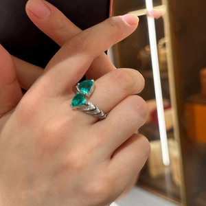 Macro detail of silver open ring featuring two triangle green stones and pavé set crystals