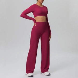 Detail of high-waist wide-leg yoga trousers and long-sleeve crop top in deep pink fabric