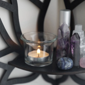Minimalist black wooden lotus crystal shelf with lit candle and natural crystals