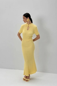Dettaglio dell'abito in maglia giallo chiaro con trama a coste e scollatura con laccio