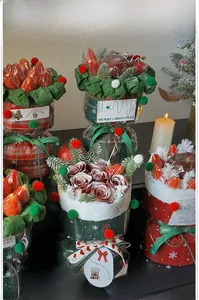 Detailed Christmas gift box with fresh strawberries, red roses, and festive ribbons