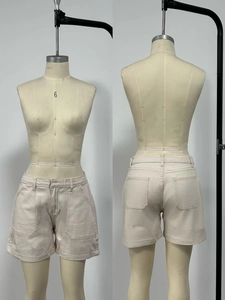 Dettaglio di pantaloncini di jeans beige a vita alta con tasche cargo e vestibilità