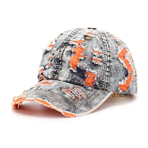 Detailed macro of distressed washed denim baseball cap with orange layered rip details