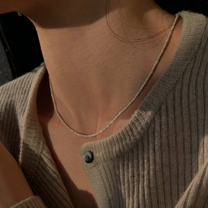 Close-up of minimalist S925 sterling silver chain on model neck highlighting sleek texture