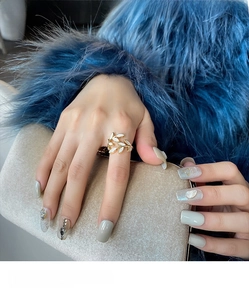 Detail of gold leaf ring with white shell inlay held against a navy fur background