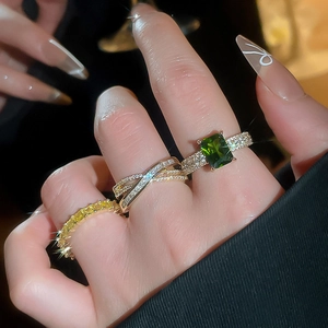 Detailed view of 18k gold plated rings featuring emerald, silver pavé, and yellow zircon