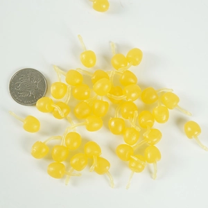 Miniature yellow PVC cherry fruit charms shown next to a coin for scale reference