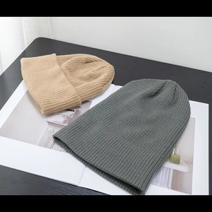 Semplici berretti in maglia a coste in kaki e verde-grigio per uomo e donna su libro