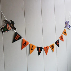Macro detail of paper Halloween banner featuring orange and black flags with witch cutouts