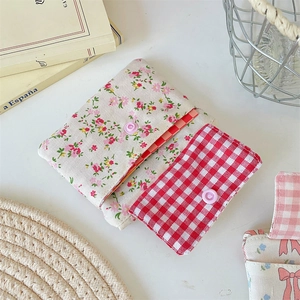 Detailed close-up of floral and checkered fabric coin purses with snap button closure
