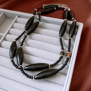 Detailed macro view of ethnic tiger eye stone beads and black oval glass bead necklace
